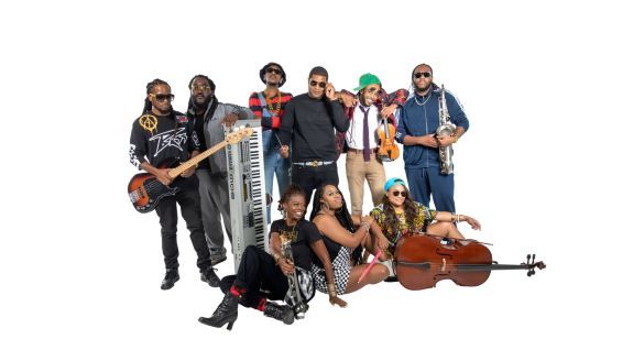 A group of musicians pose with various instruments such as a keyboard, a guitar, a violin, a saxophone, a cello, and a trumpet. 