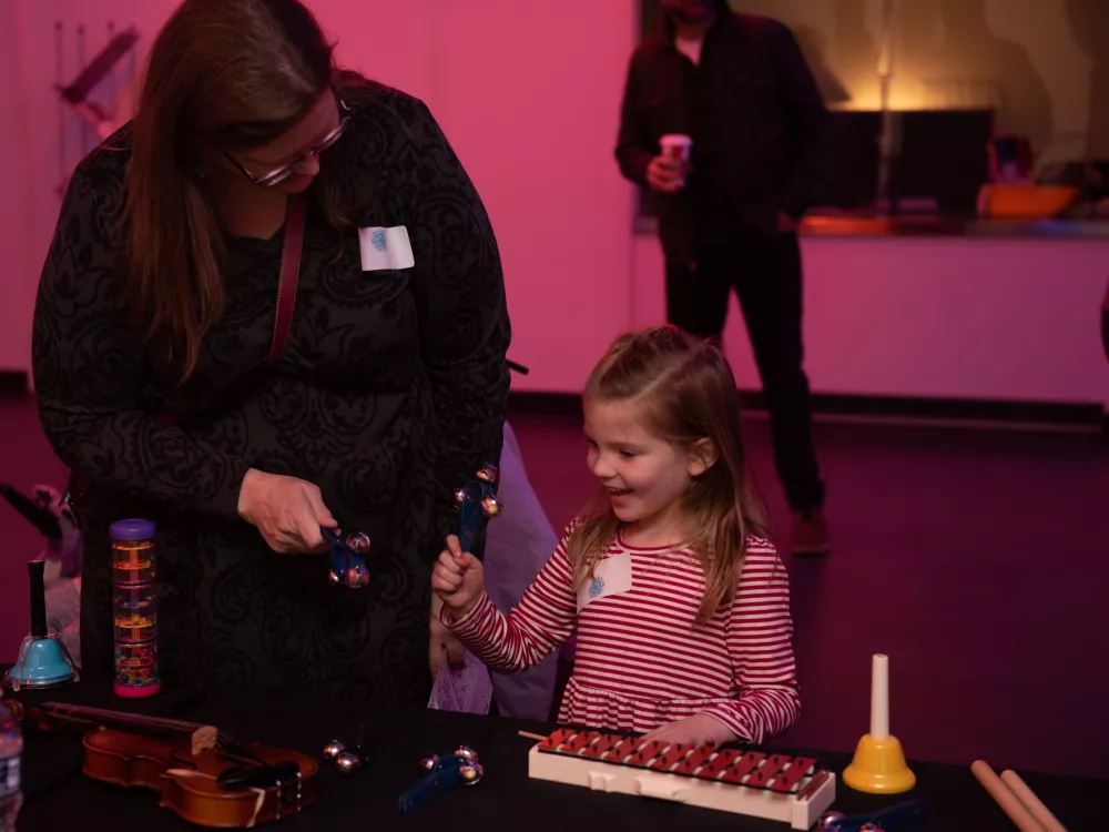 Mother and daughter visiting the instrument petting zoo in the HT Lobby.