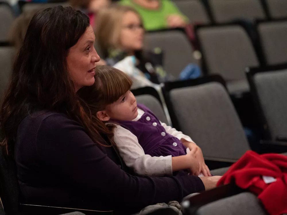 Mother and daughter watching a performance.