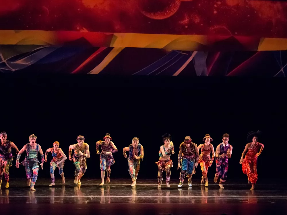 A group of dancers on stage mid-performance.