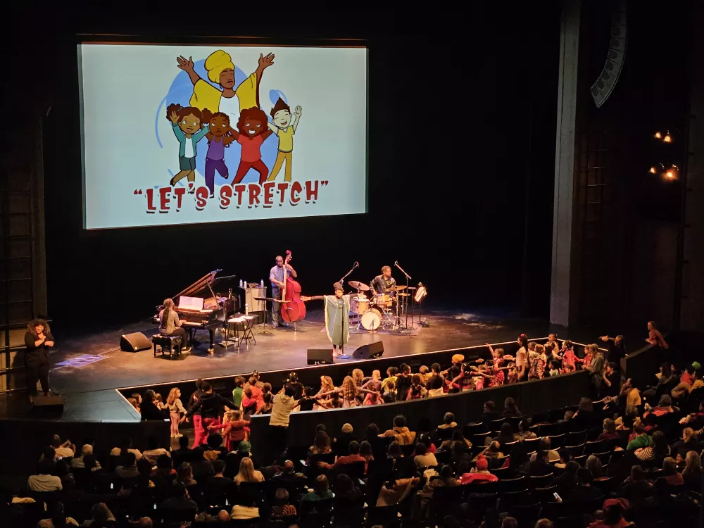 Children dancing near the stage while following along to the singer and band.