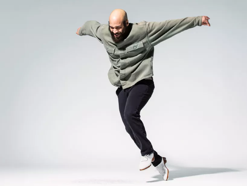 Jumanne mid-tap performance in front of a blank white backdrop.