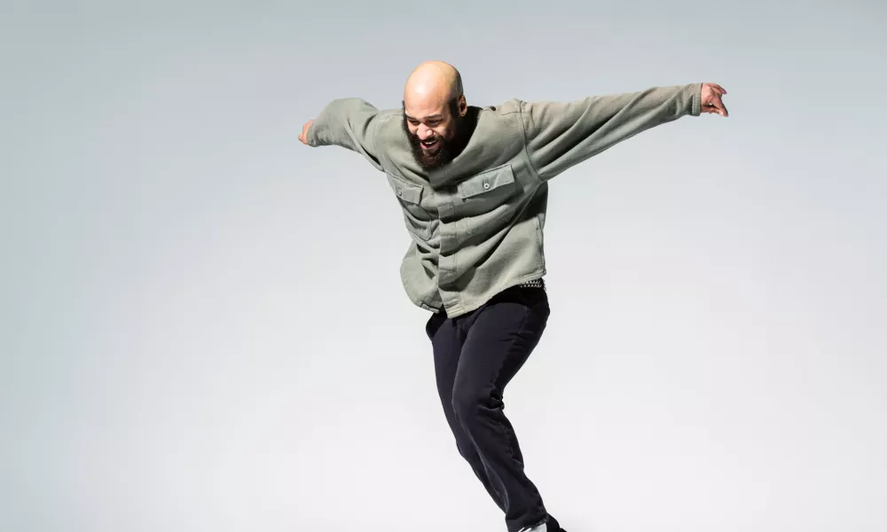 Jumanne mid-tap performance in front of a blank white backdrop.