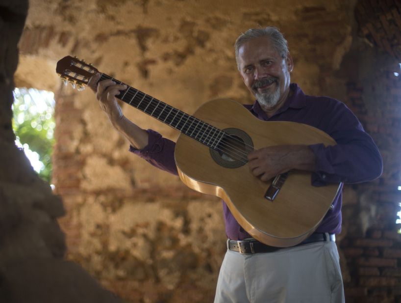 Modesto Nieves smiling and holding a guitar