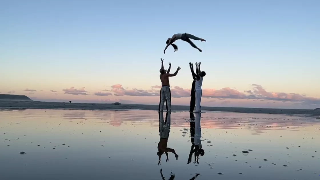 Four dancers throwing another dancer in the air.