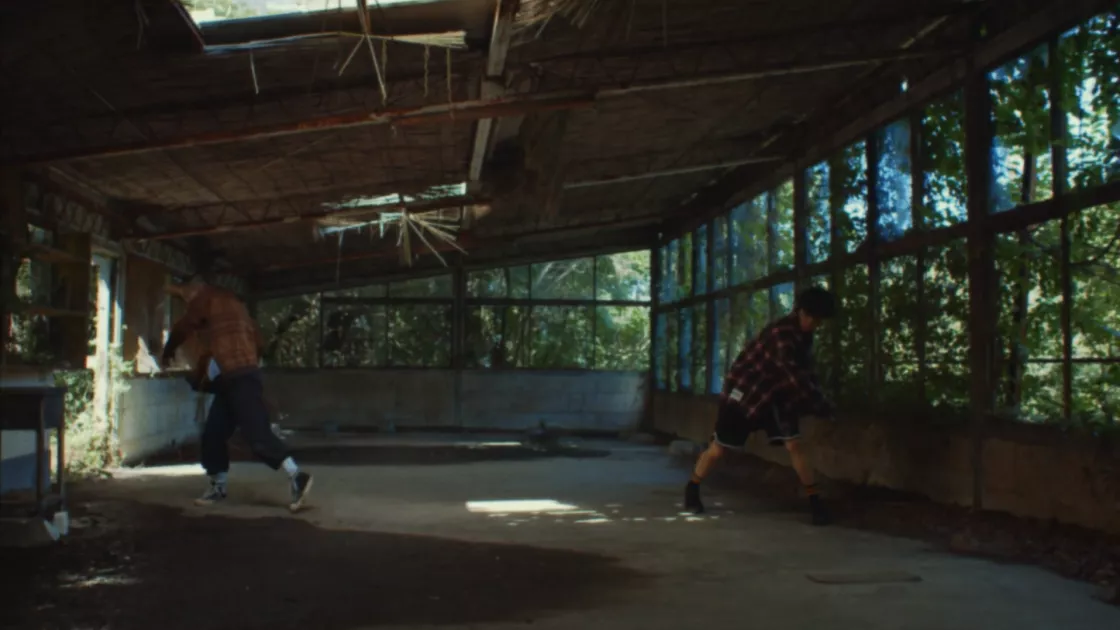 Two dancers standing opposite each other inside an empty building 