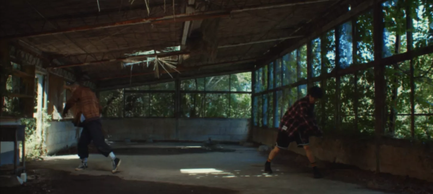 Two dancers standing opposite each other inside an empty building 