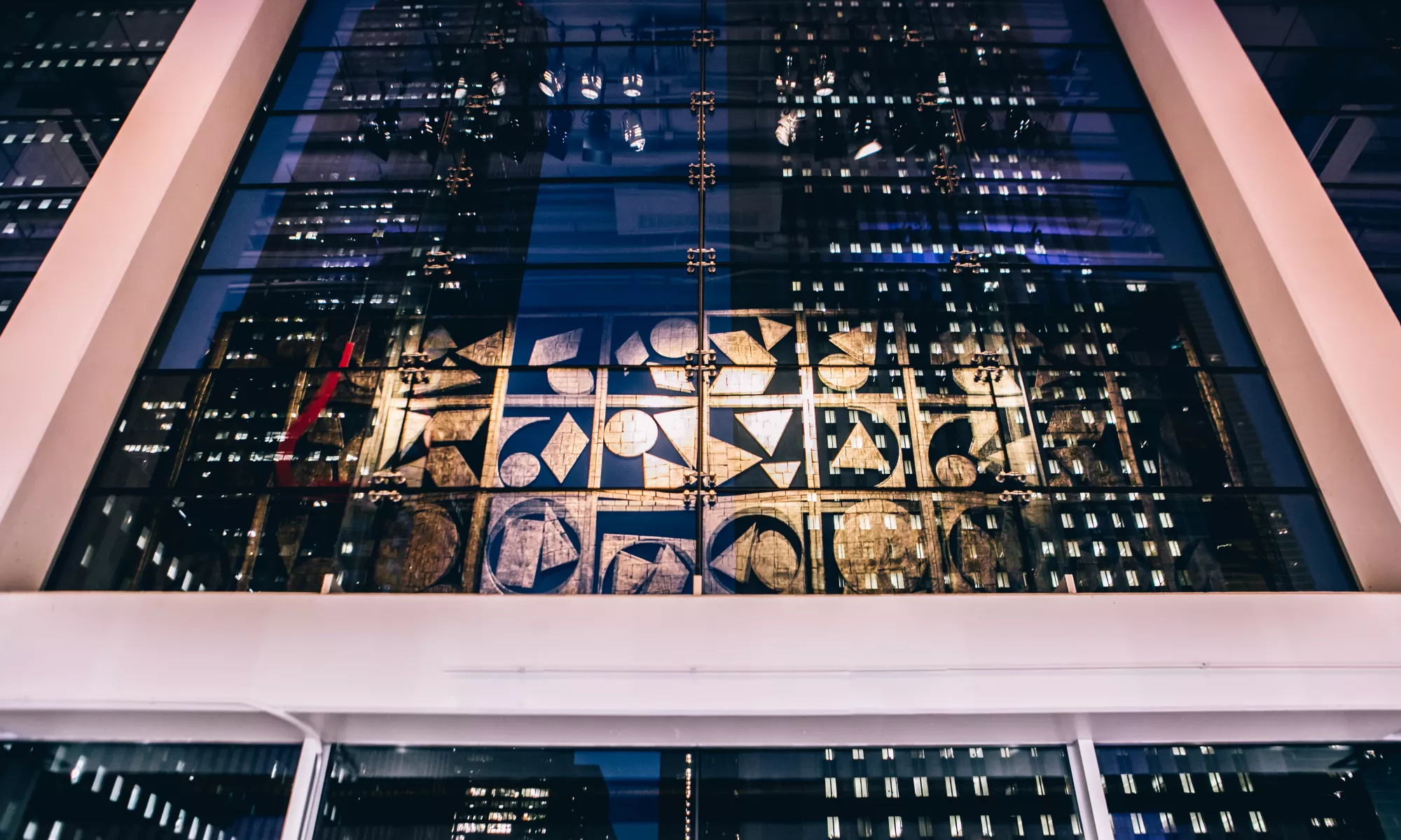 Image of Nevelson hanging artwork handing in the lobby of the Harris Theater with the reflection of Chicago high rise