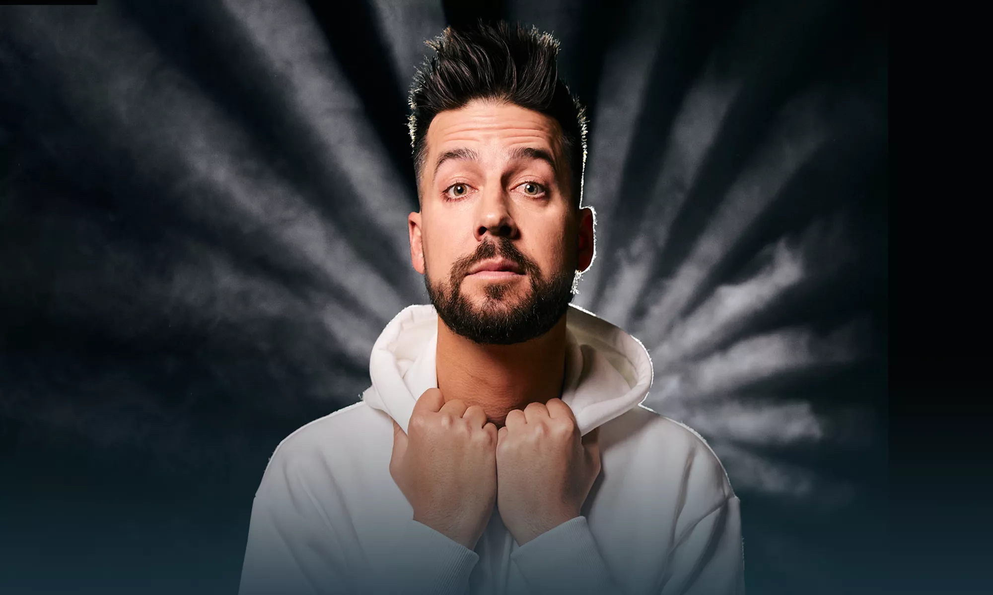 John Crist holding the front of his hoodie with both hands.