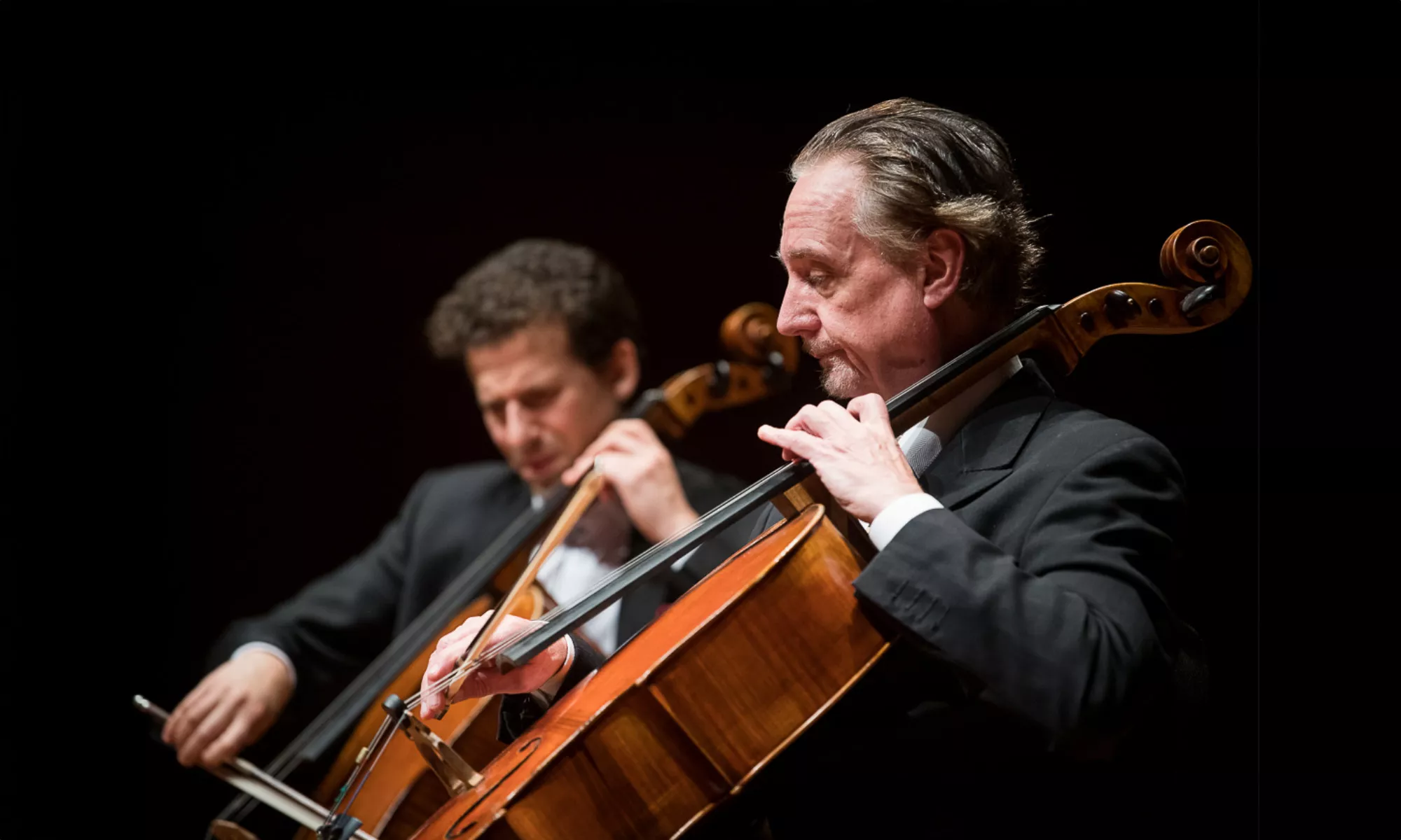 David Finckel playing on stage with another musician. 