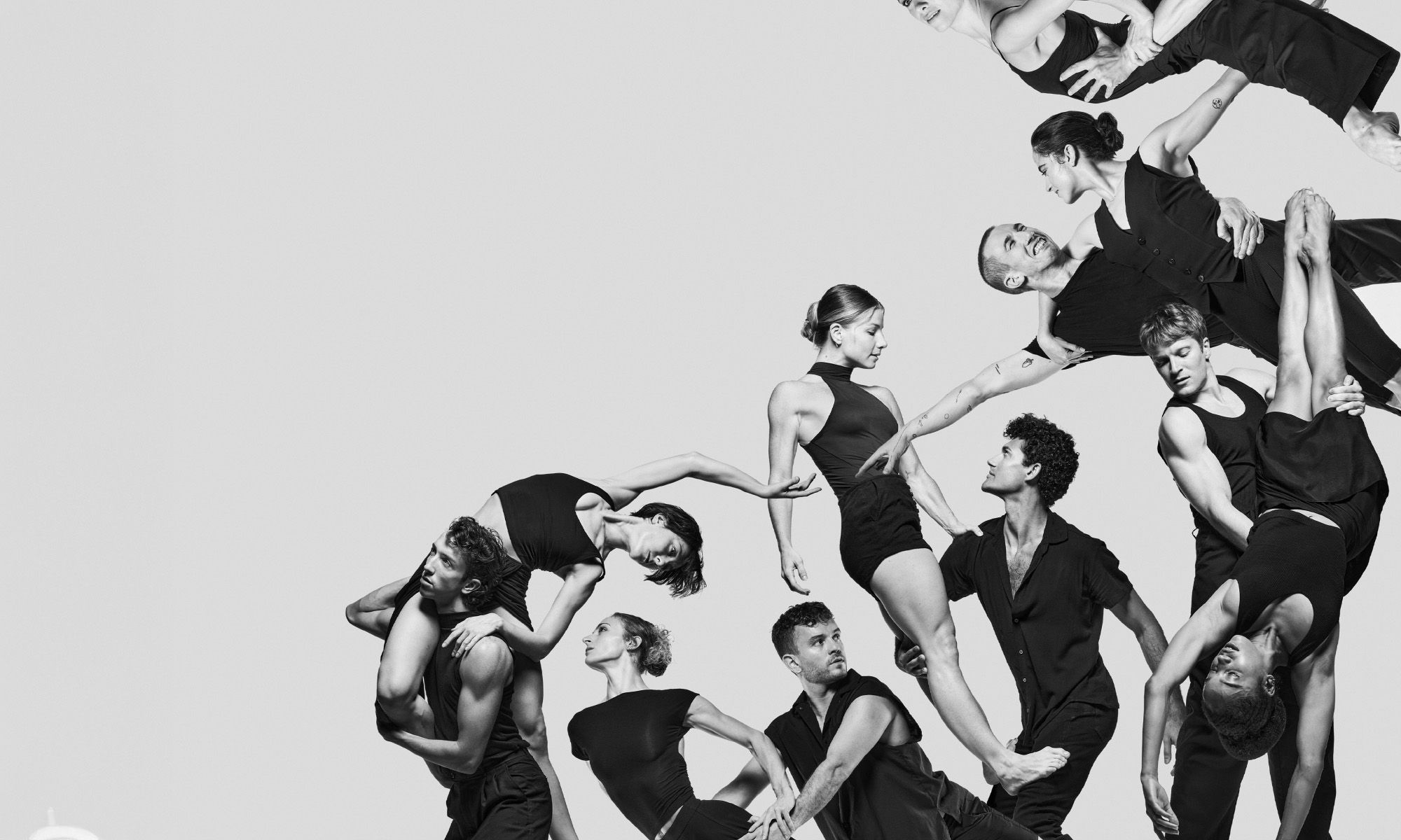 Black and white image where several dancers are lifting each other up.