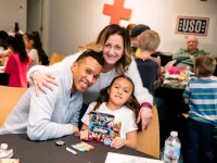 Families from USO Illinois enjoying a pre-show pizza party before the Family Series matinee of Flip Fabrique.