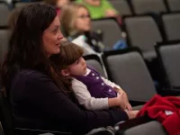 Mother and daughter watching a performance.