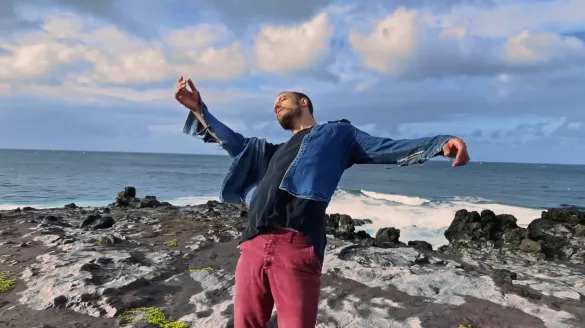 Dancer extending their arms in front of an ocean