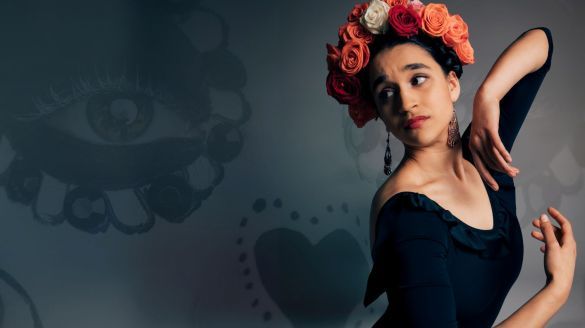 A photo of a latina woman in a black dress with roses on her head, a faint skull in the background.