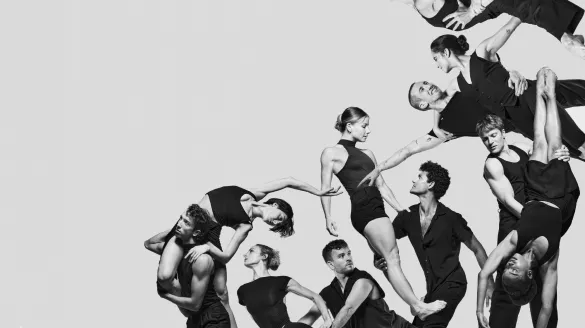 Black and white image where several dancers are lifting each other up.